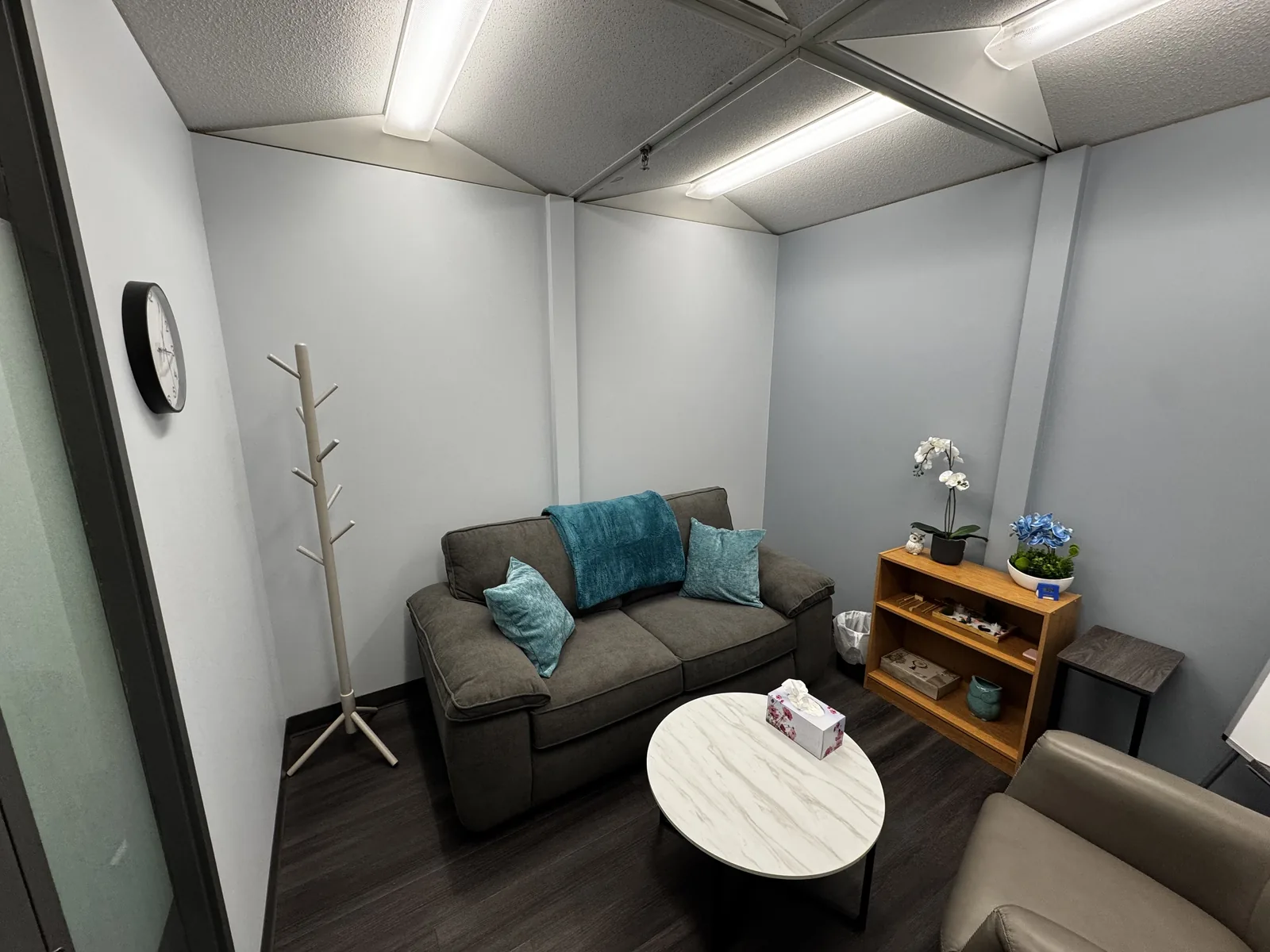 A private counselling room at Flutterby Psychology, with a sofa, side table and tissues